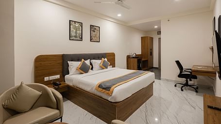 Well-furnished guest room with desk, chair, and king-size bed at Lemonridge Hotels, IDPL Balanagar.