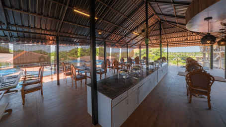 Our restaurant offering 4-person seating areas, a central buffet counter, and a view of Morjim Beach - Perfectstayz Koko Maya