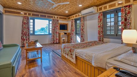 Spacious room with twin beds and modern amenities at Royal Comfort Regency, combining practicality and comfort.