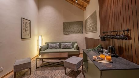 Living area with a sofa, table, and wall-mounted photographs at The Chamomile Estate.
