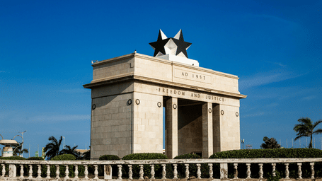 A facade view of the Independence Arch in Accra, Ghana with blue sky in the background.