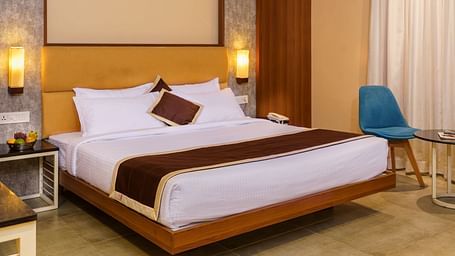 Room with bed and chair with table at Wyt Hotels, Rameswaram