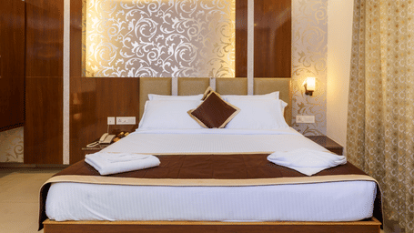 Deluxe room with bed and pillows at Wyt Hotels, Rameswaram