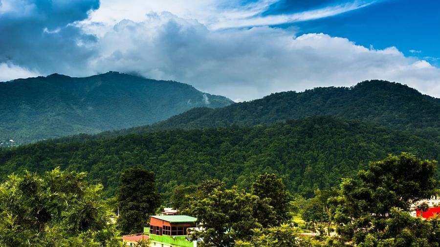A wide view of mountains with a sky with scattered clouds in the background