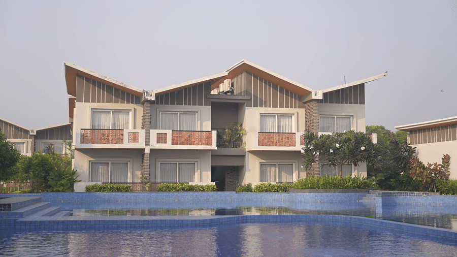 A row of 2-storey hotel villas with balconies overlooking the pool area at Hotel Sonar Bangla, Mayapur.