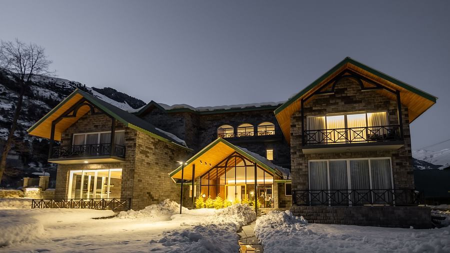 Cosy wooden facade glowing at twilight at Nivasana Manali.