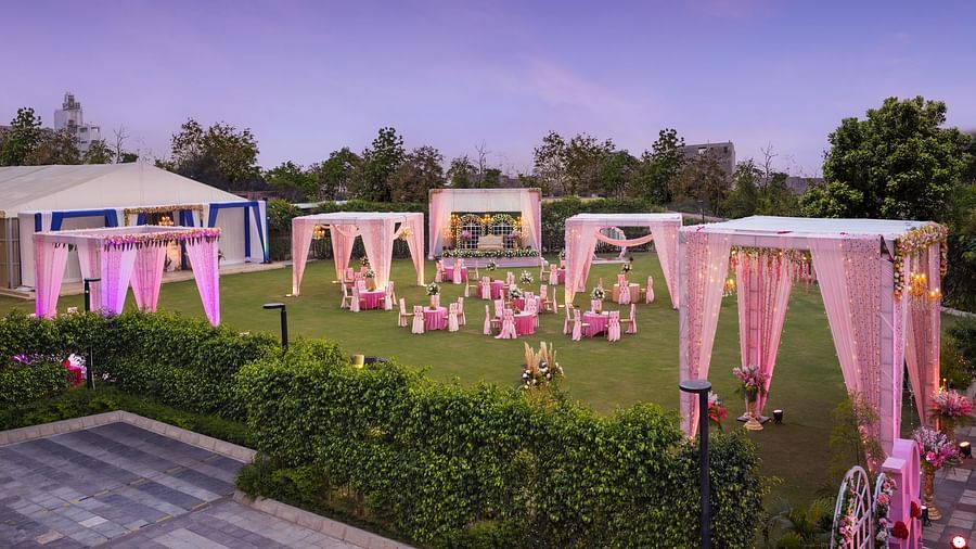 a view of a group of canopies in an open space with clusters of tables and chairs scattered across the space - The Hideaway Banquets & Lawns, Greater Noida