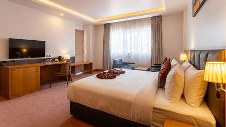The Presidential Suite at Mandala Norling Lords Prime Kathmandu featuring a king size bed, a flat-screen TV, and warm ambient lighting.