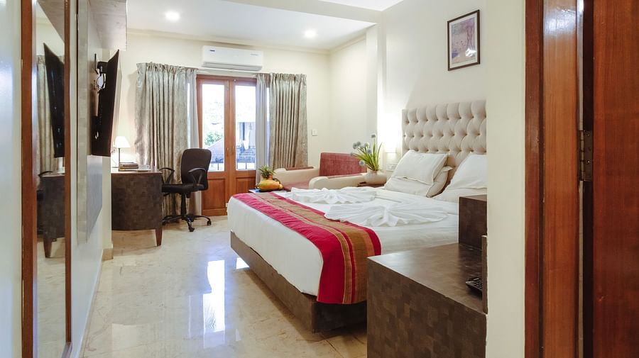 A bedroom with a bed, neutral tones, and ceiling fan, opening to natural light – The Verda de Miranda Resort.