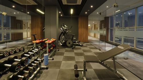  An image of a gym featuring various fitness equipment like dumbbells, wights, treadmills, and benches at Tulip Inn, Zirakpur