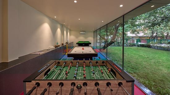 a foosball table, an air hockey table and a pool table in the recreation room at ABN Sarovar Portico, Jim Corbett