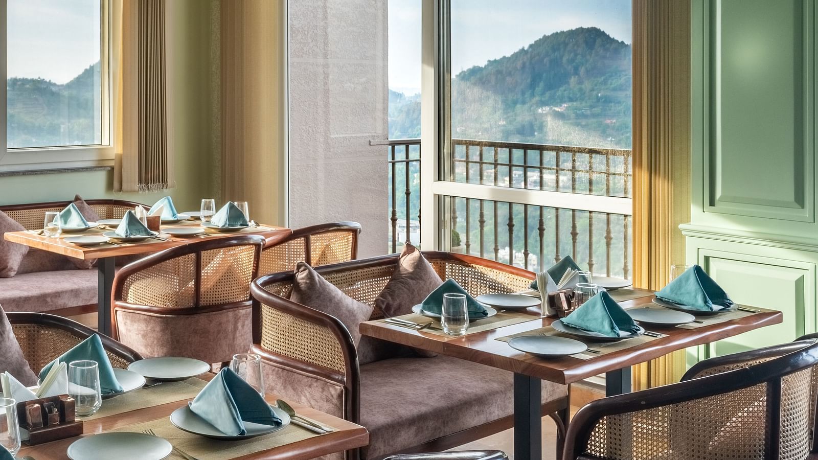 an image of a dining space filled with natural light, chairs and tables are placed with cutlery and hand towels at Mountoria Retreat, Naukuchiatal