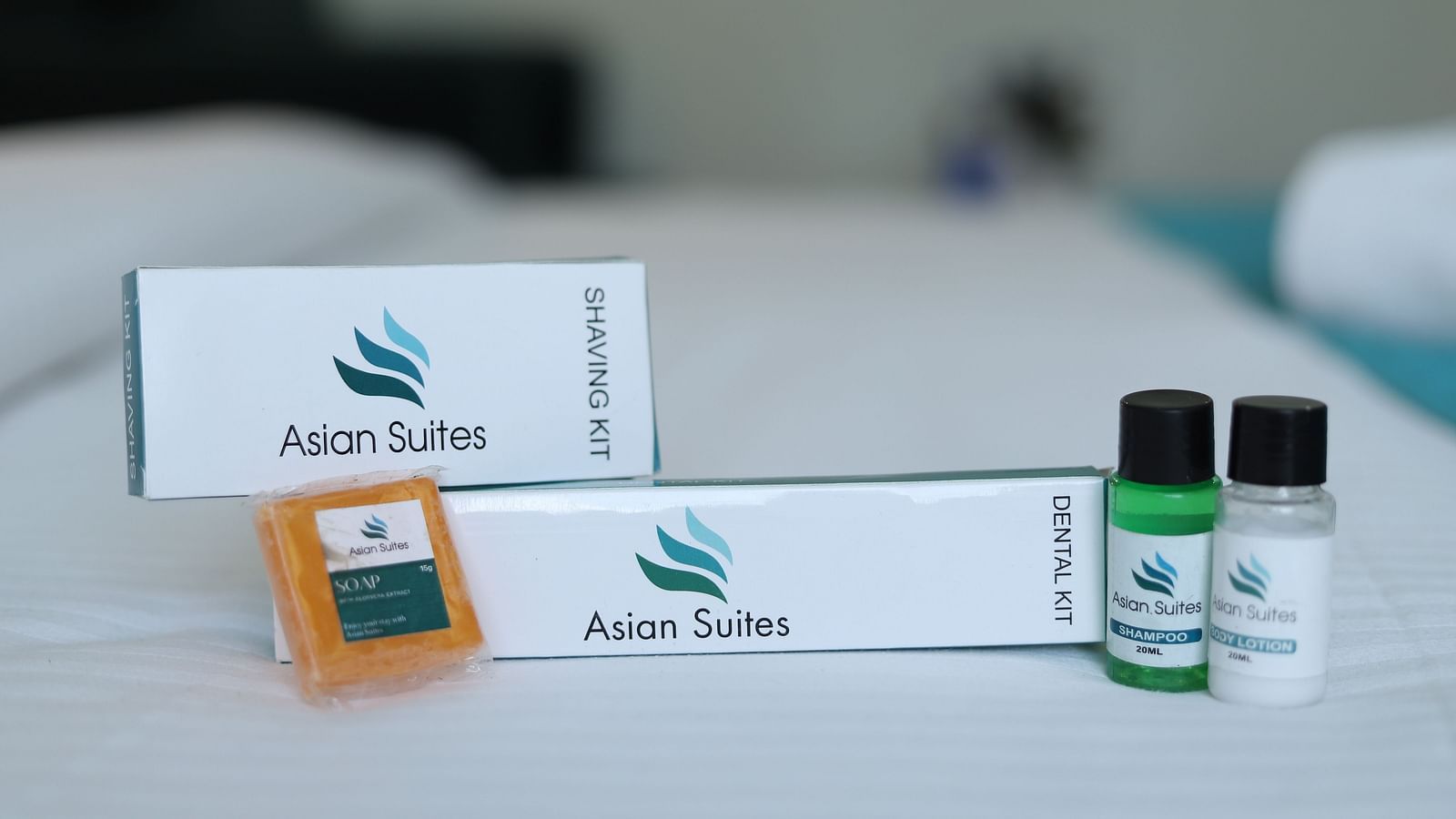 Toiletries including soap, shampoo, and lotion are neatly arranged on a surface - Asian Suites IFFCO Metro, Gurgaon