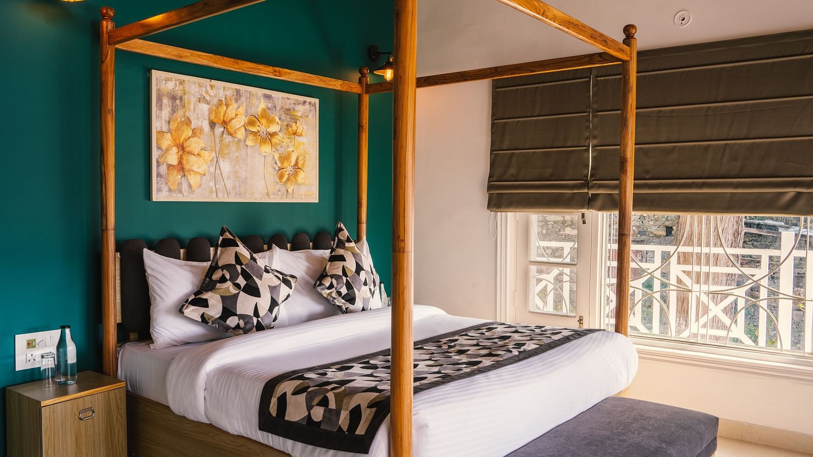 A spacious bed with a wooden frame, a photo frame above the headboard, and a half-closed window to the side at BluSalzz Villas - The Green Roof, Bhimtal.
