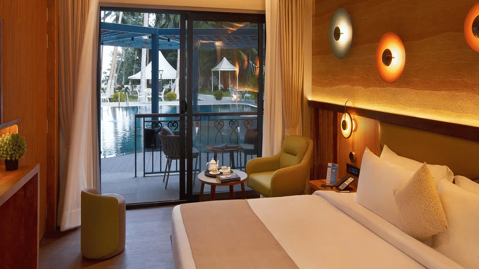 Coral Sapphire at Coral Reef Resort and Spa in Havelock featuring a plush bed and a seating space next to it with the door to the outdoor lounge area beside it  