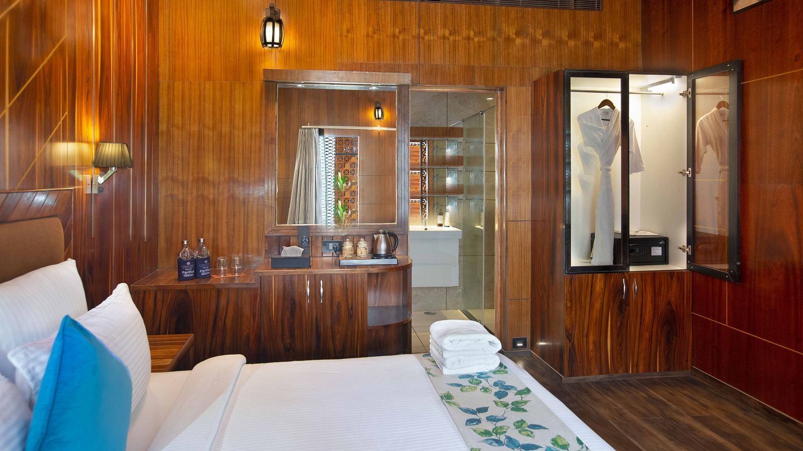 Image of Coral Azure at Coral Reef Resort and Spa in Havelock featuring a double bed with bath towels on it and a mirror next to the bed with tea and coffee maker under it on the desk 