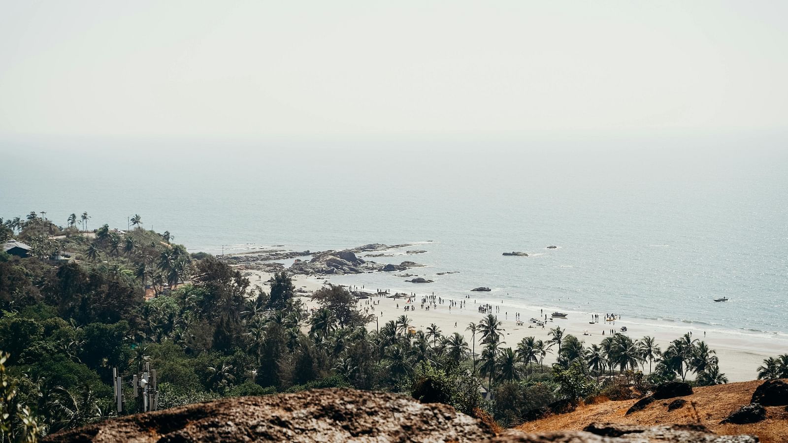 Aerial view of a coastal cliffside with scattered rocks and sea beyond at De Soul Santé Hotels & Resorts.
