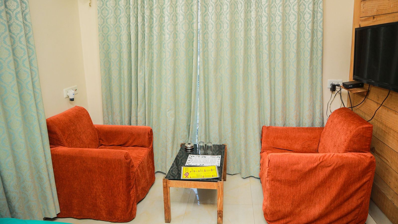 image featuring a common seating area with crimmison coloured cushioned chairs with a centre table in the middle