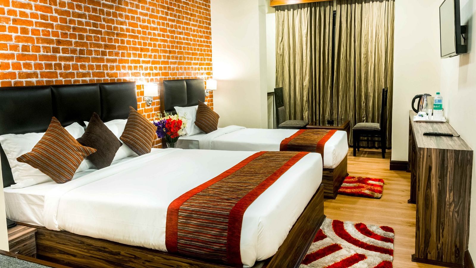 An image of a premium room with with twin beds, bed side tables, flat screen tv, chairs and tables, and other amenities - Ecotel Tin Tin, Bijanbari