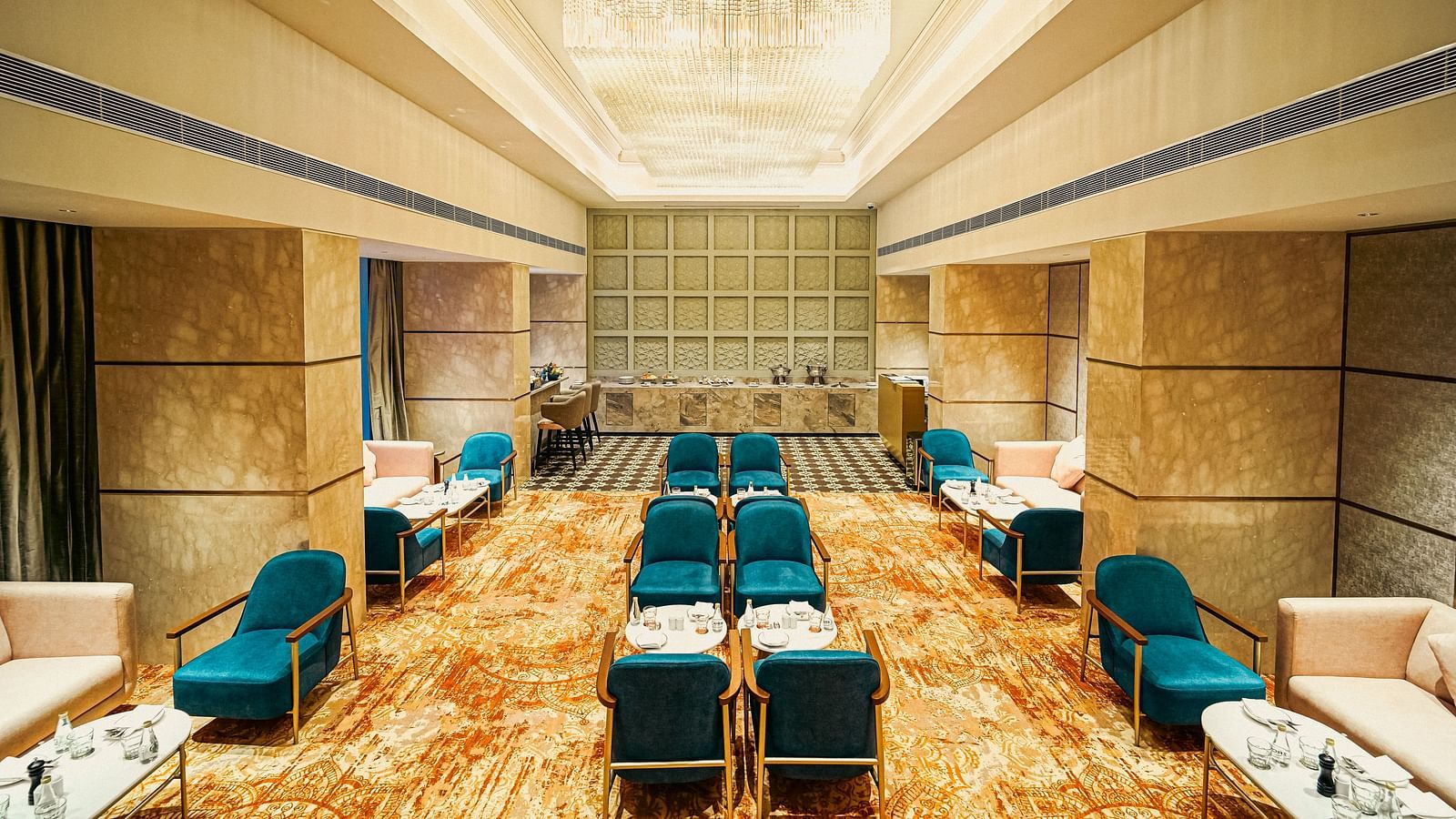  A luxurious lounge area featuring plush seating, a chandelier, and stylish decor - Grand Madurai by GRT Hotels
