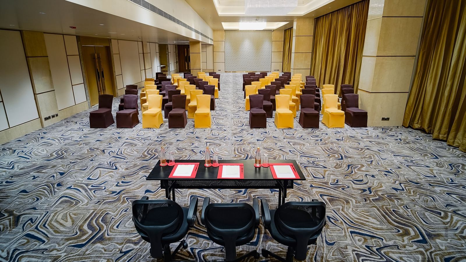  A formal meeting space with classroom-style seating, elegant lighting, and ample room for presentations - Grand Madurai by GRT Hotels
