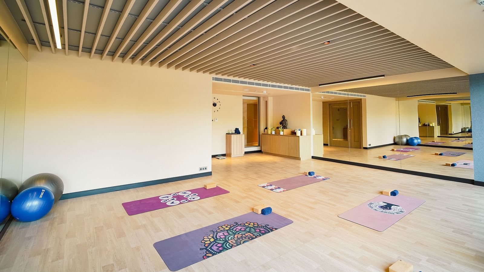 Yoga Studio in Madurai featuring yoga mats and a stability ball, placed in front of a large mirror - Grand Madurai by GRT Hotels
