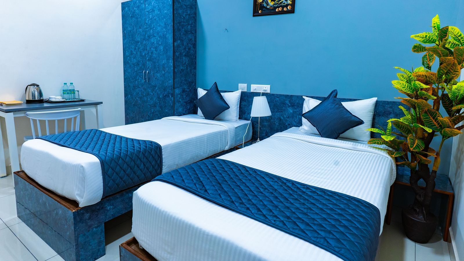 An image of a bedroom with twin bed, bedside table next to it, AC, flat TV screen, etc. - Hotel Aerotel, Hyderabad - A Unit of Comfort Hometel