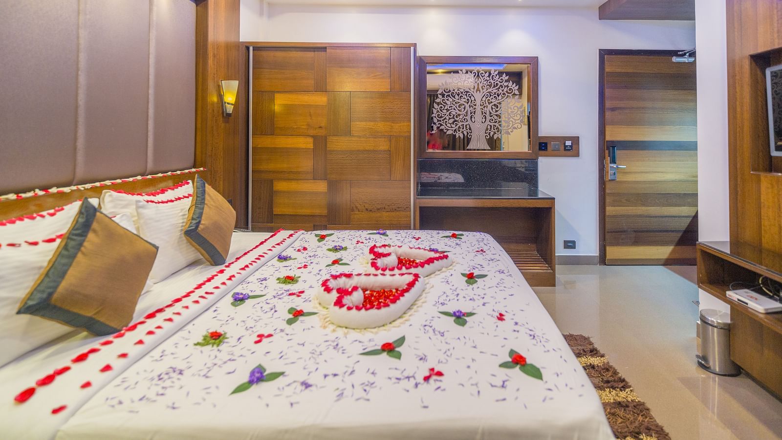 Side view of a room with a bed decorated with flower petals at Hotel Altitude, Madikeri.
