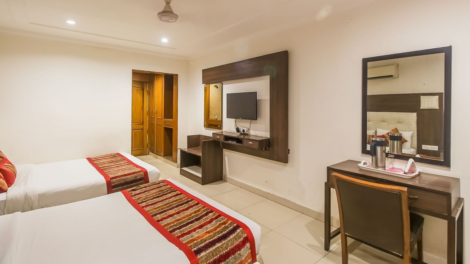 Well-lit Family Room with two queen size beds, wooden accents, and contemporary furnishings - Hotel Diamond Plaza, Chandigarh.