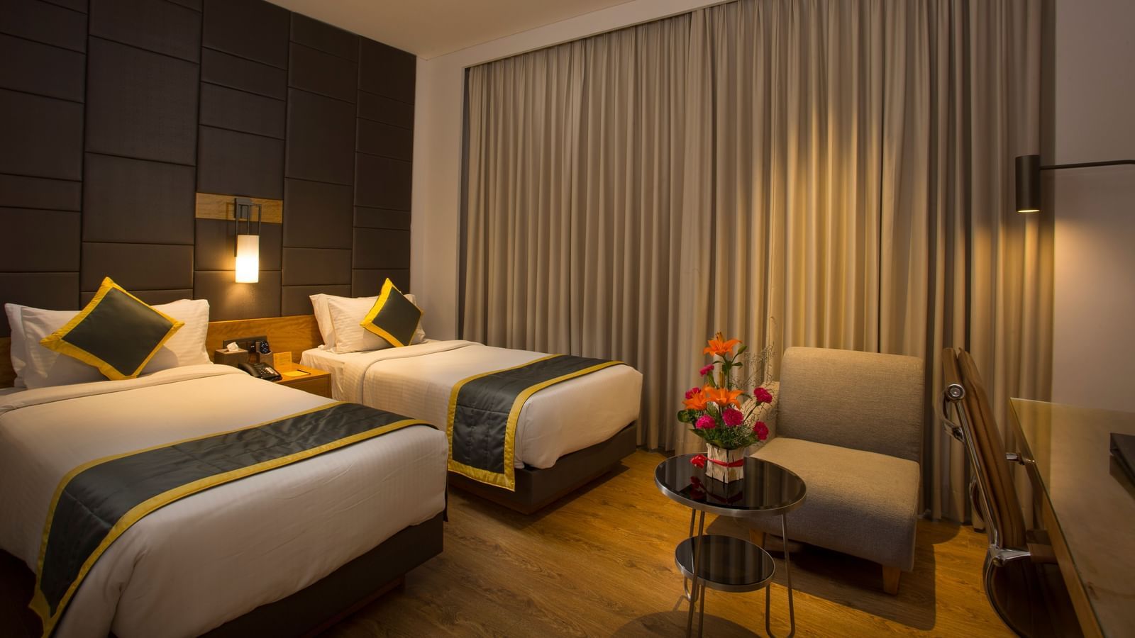 a bedroom with two single beds and a sofa - Hotel Fountain Tree By TGI - JP Nagar, Bangalore
