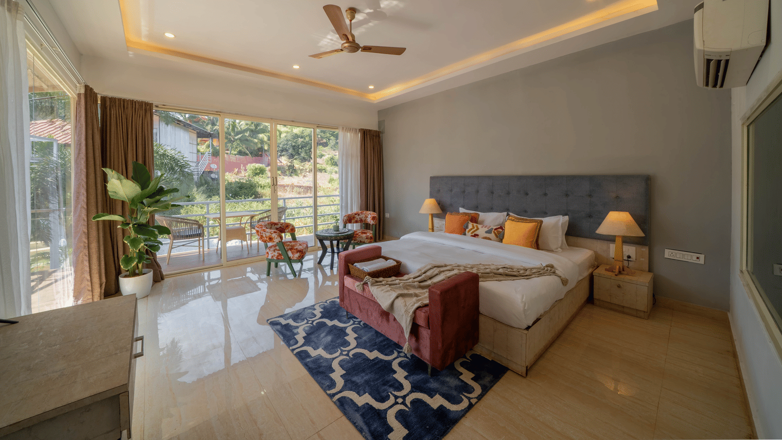 A room featuring a king size bed, air-conditioning, a ceiling fan, and a balcony - Perfectstayz Koko Maya