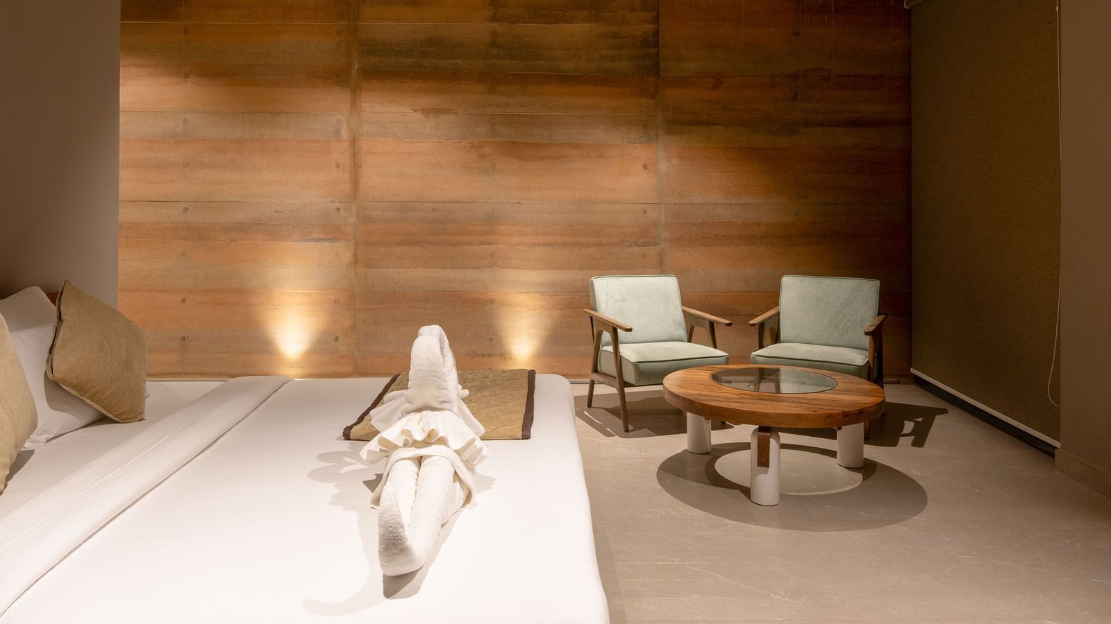 A spacious living area with textured wooden walls, a seating arrangement, and a rug on the floor | Gaia Room | RD's Nature Retreat, Bangalore