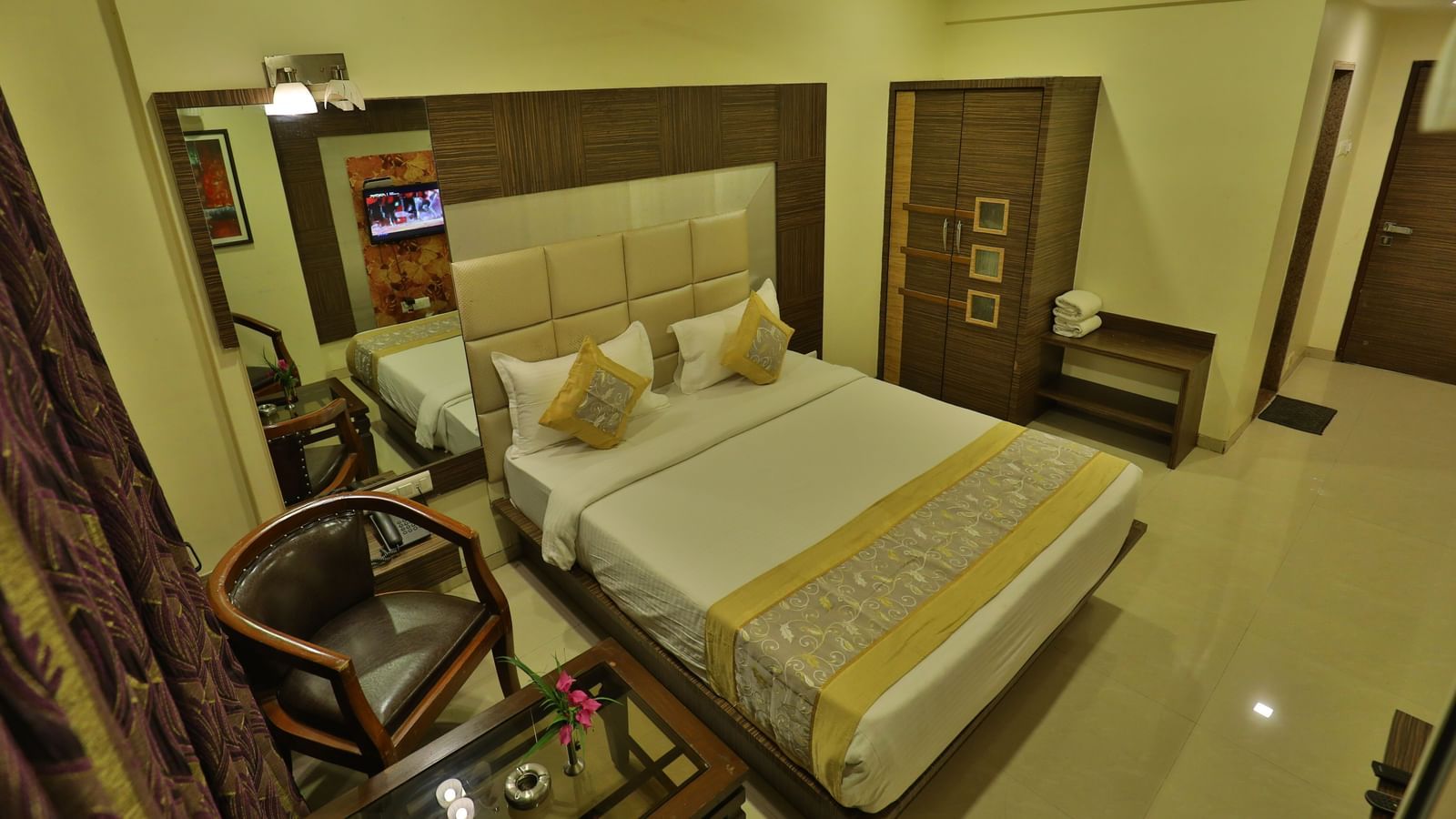 An expansive view of a well-appointed hotel room featuring a bed, seating, and contemporary decor - Retreat Heritage, Lonavala