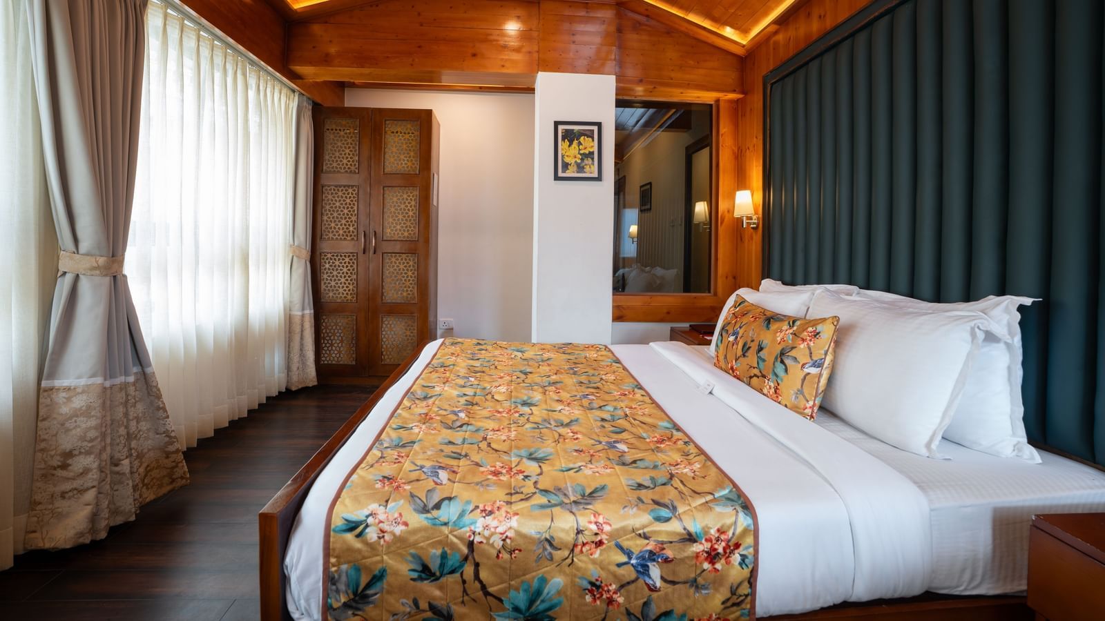 Suite at Summit North Star, Gangtok featuring a double size bed, a large window with curtains, and a lamp lit near the bed.