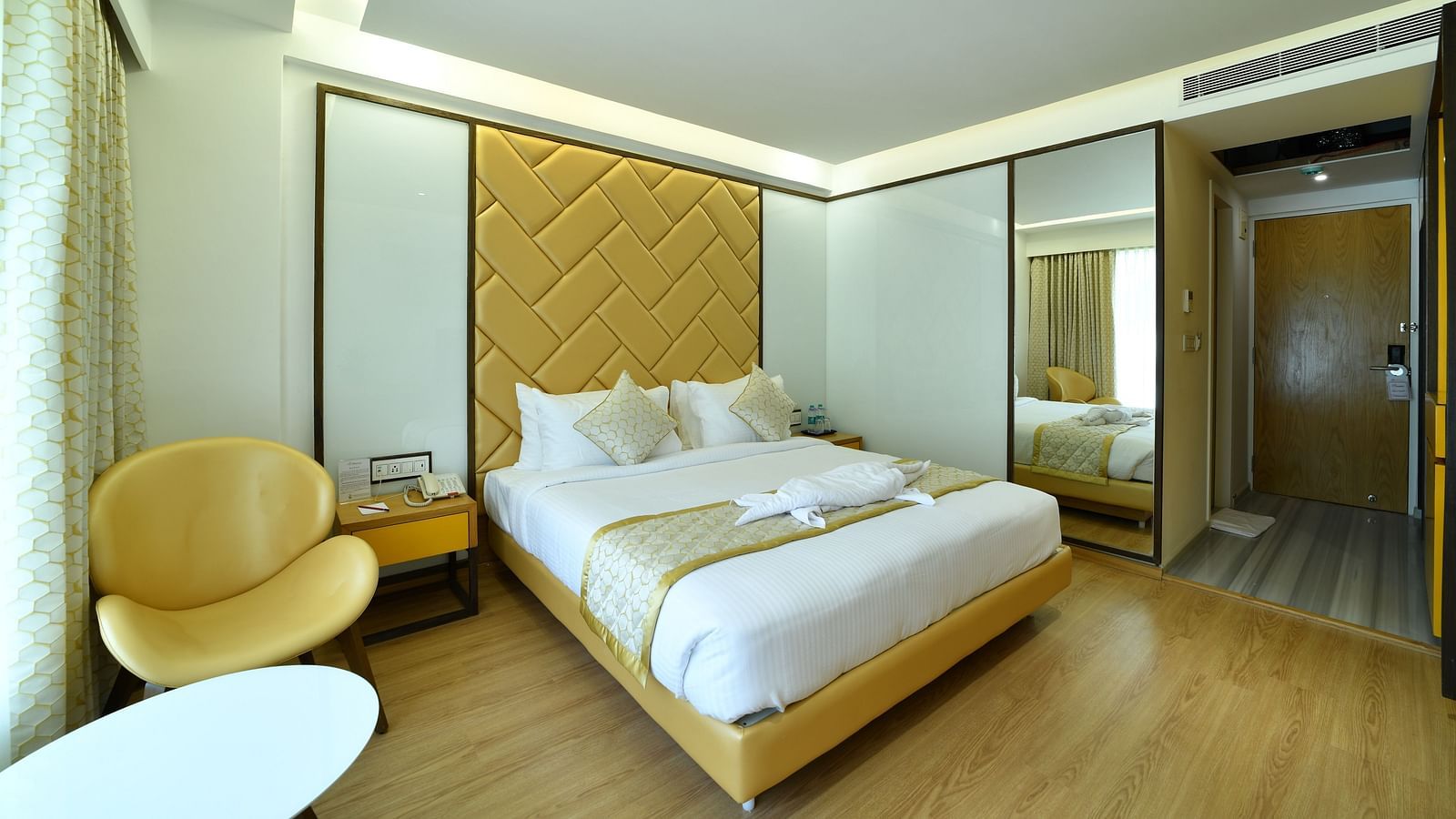 An image of a room with a large bed and with a fancy headboard -The President Hotel, Kumara Park, Bangalore