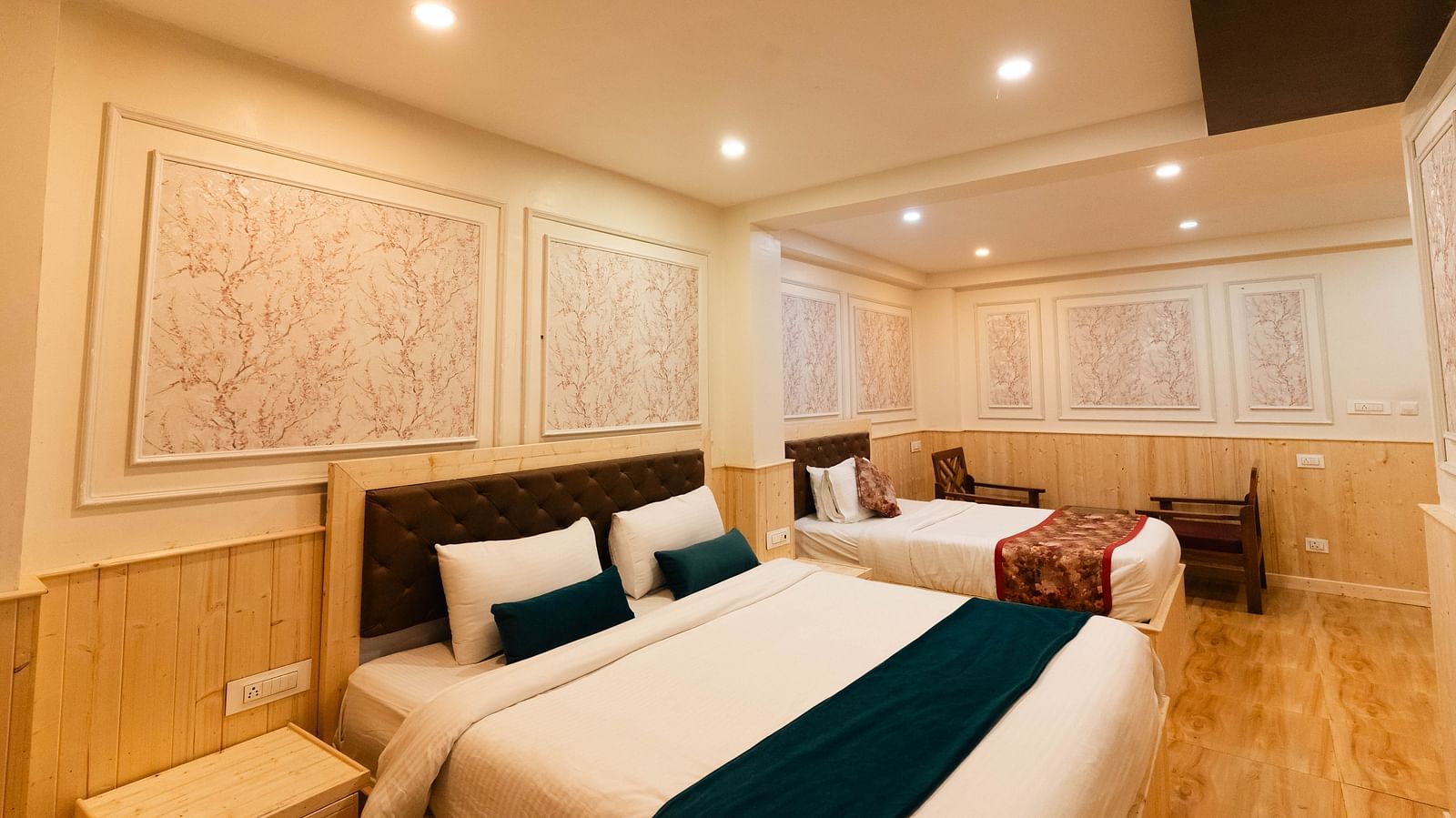 an image of a family room with two beds and two chairs at Avianna New Mandala Hotel & Spa, Darjeeling.