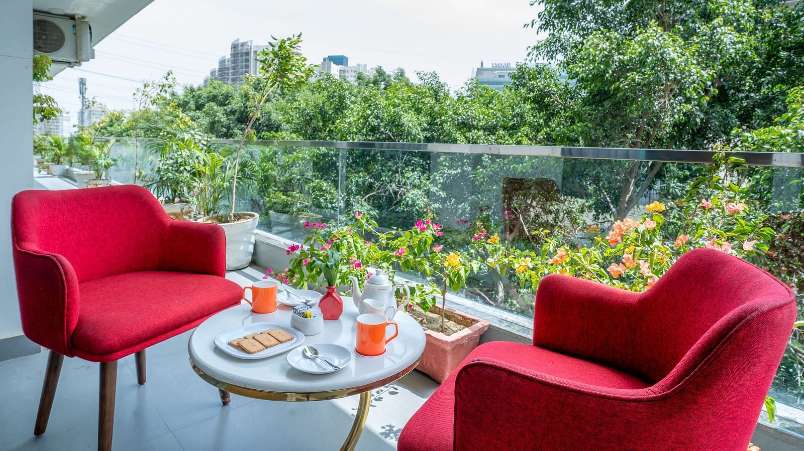 An image of a sitting area at the balcony with one centre table and two chairs | Inde Hotel Golf Course Extension