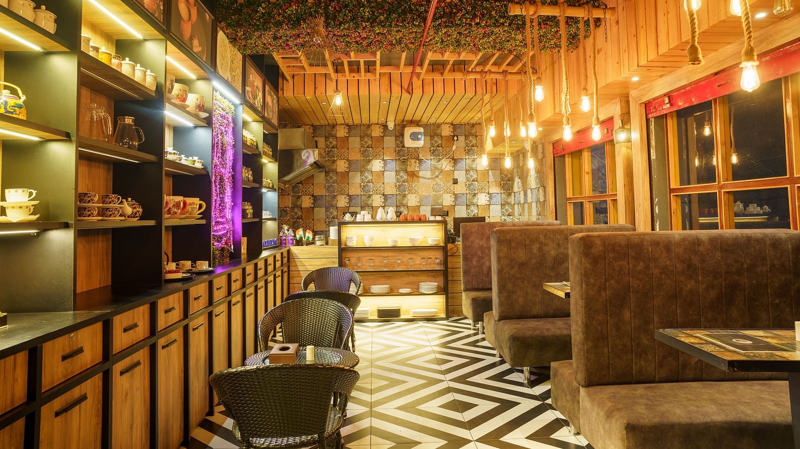 A restaurant with wooden panelled walls and ceiling, dark seating, and decorative hanging lights at Orsino Spa Resort.