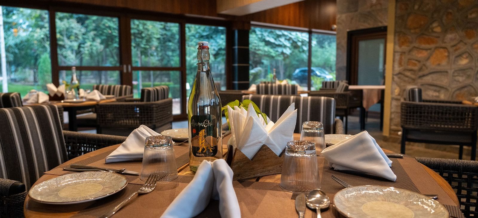 A set dining table at Aamaghati Jungle Retreat Ranthambore ready for guests with elegant place settings.