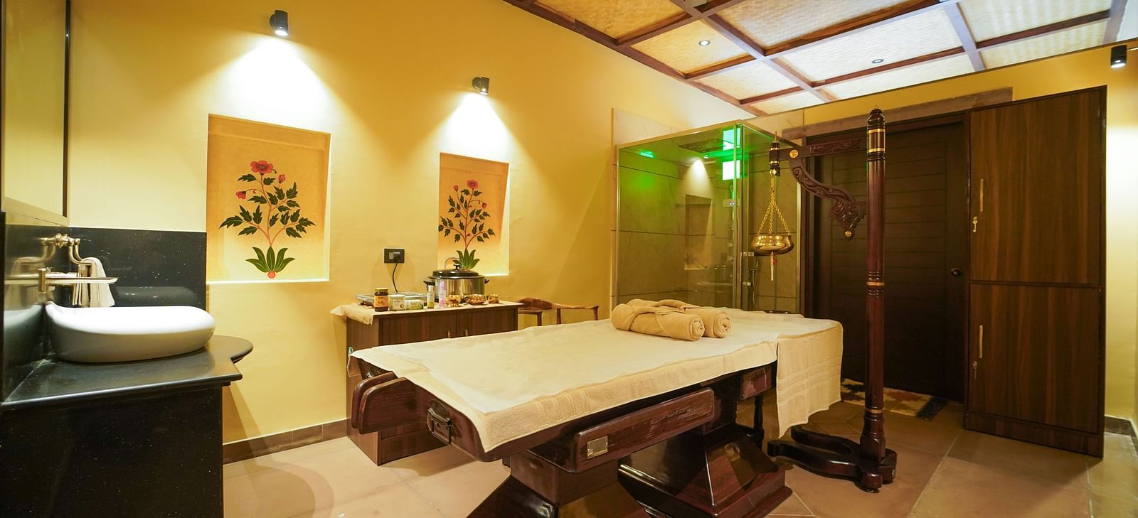  A serene spa room featuring two massage beds and traditional decor at Aamaghati Wildlife Resort.