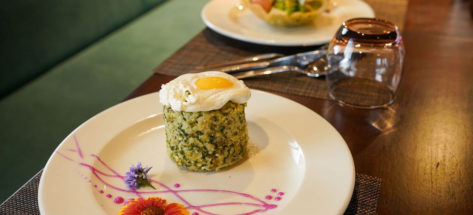 A close-up of a beautifully plated meal with a decorative element on the side at Aamaghati Wildlife Resort.