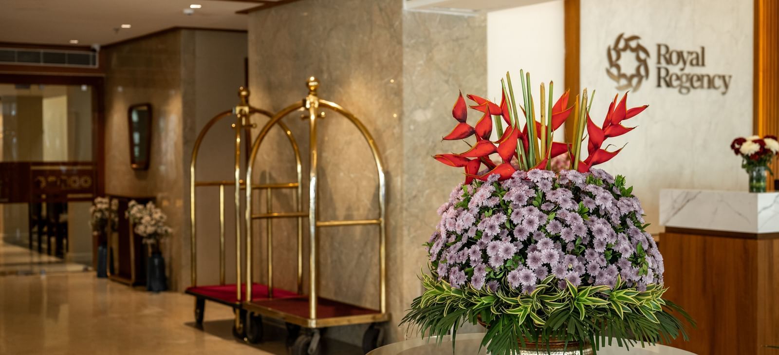Reception area with floral arrangement and concierge desk at Hotel Royal Regency Chennai