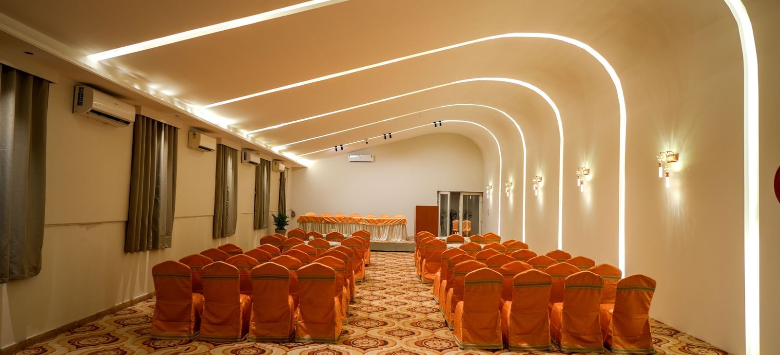 Modern banquet hall with elegant seating and ambient lighting at Pravasa Hotel Kolhapur.