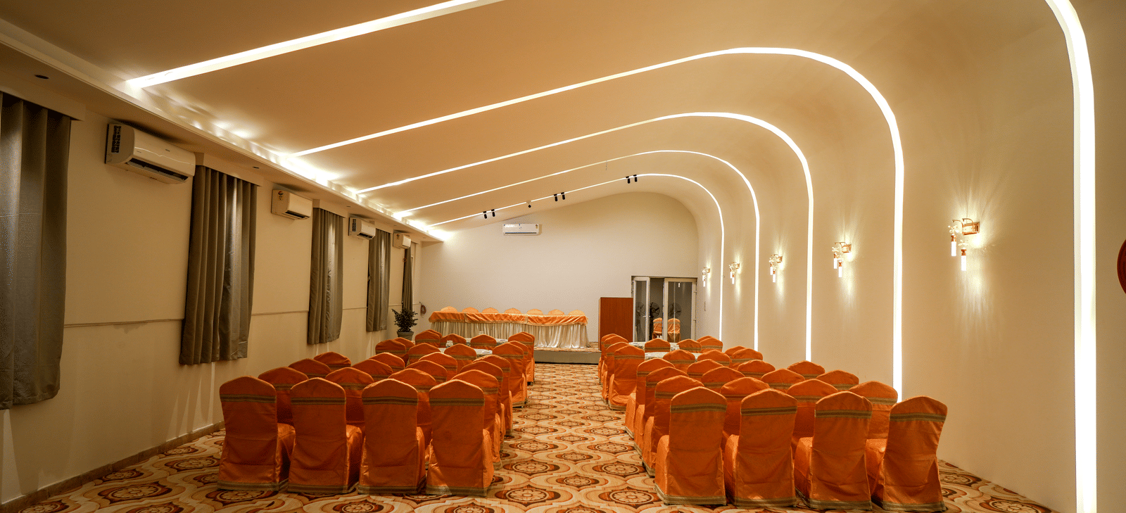 Conference hall with chairs arranged in rows at Pravasa Hotel, Kolhapur.