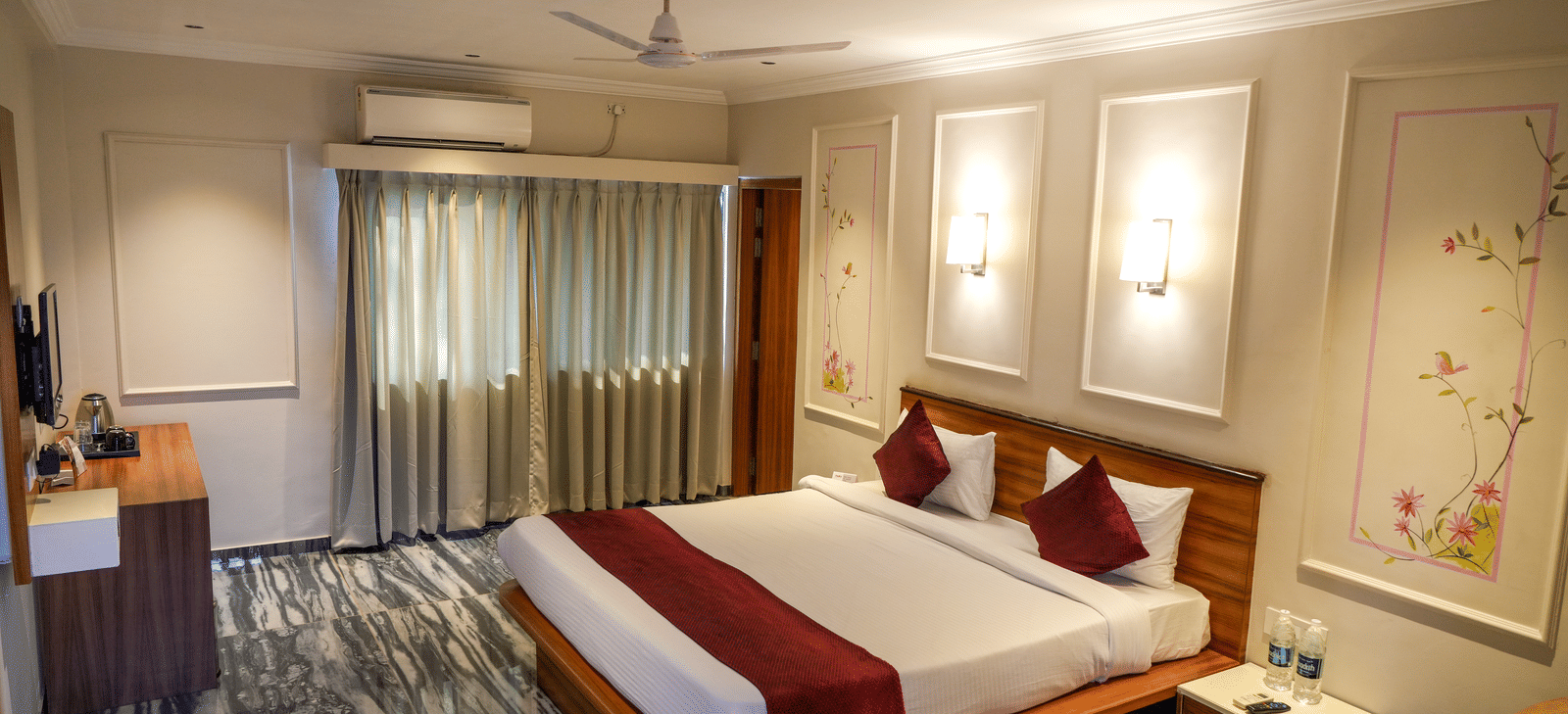  A well-designed deluxe bedroom with striking black and white patterned flooring and recessed wall lights at Pravasa Hotel, Kolhapur. 