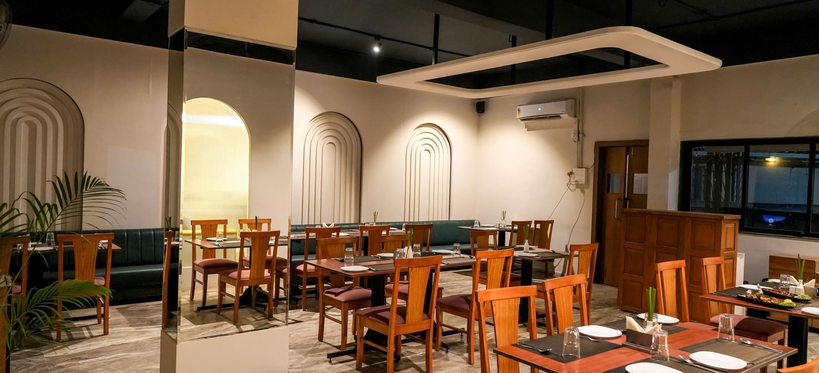 Modern restaurant with chic decor and wooden furnishings at Pravasa Hotel Kolhapur.