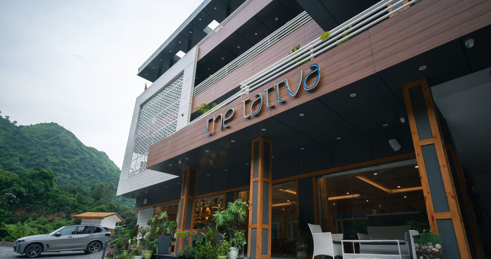 Facade of The Tattva Devaprayag hotel featuring the entrance and three floors.
