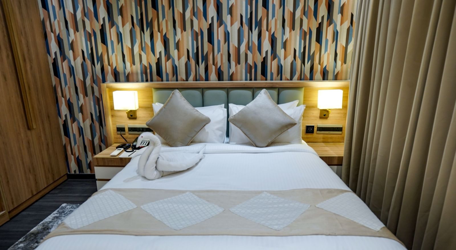 A close-up shot of the double bed at Deluxe Room at M2 Square by Monday Premium with swan made of towel kept on the bed.