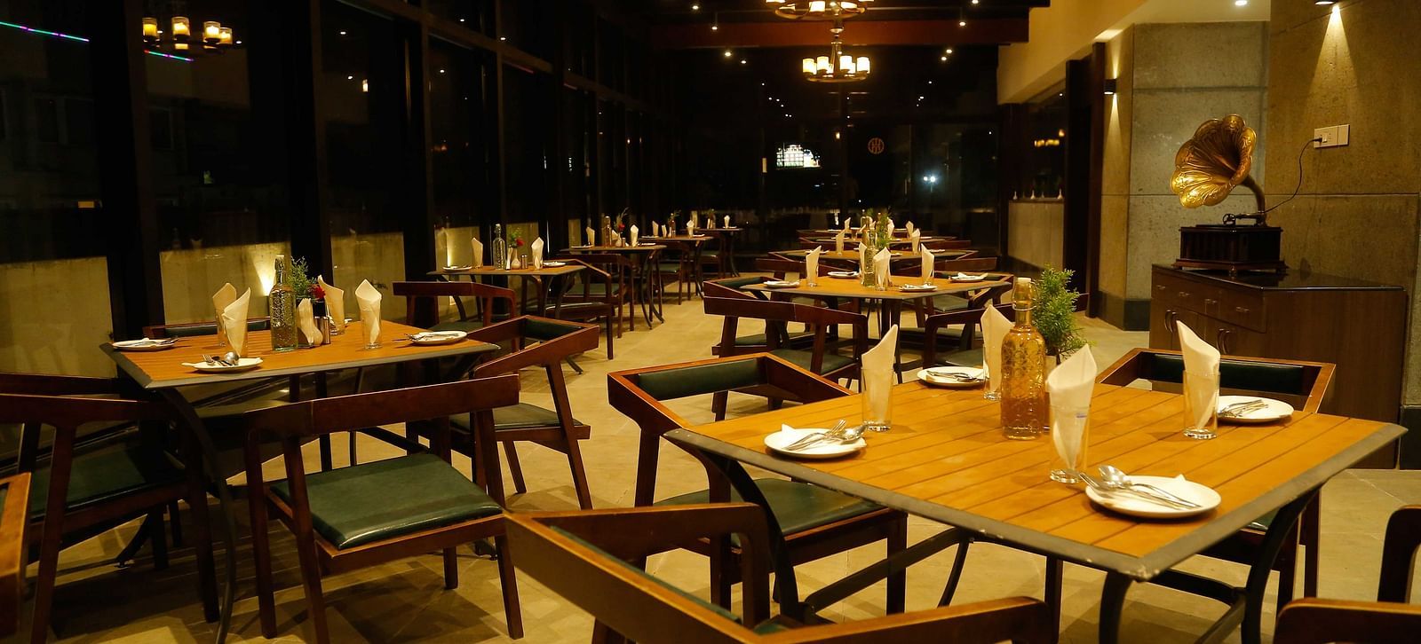 dining area of a rooftop restaurant with variously arranged seating areas at The Hamuse Hotel, Kodaikanal.