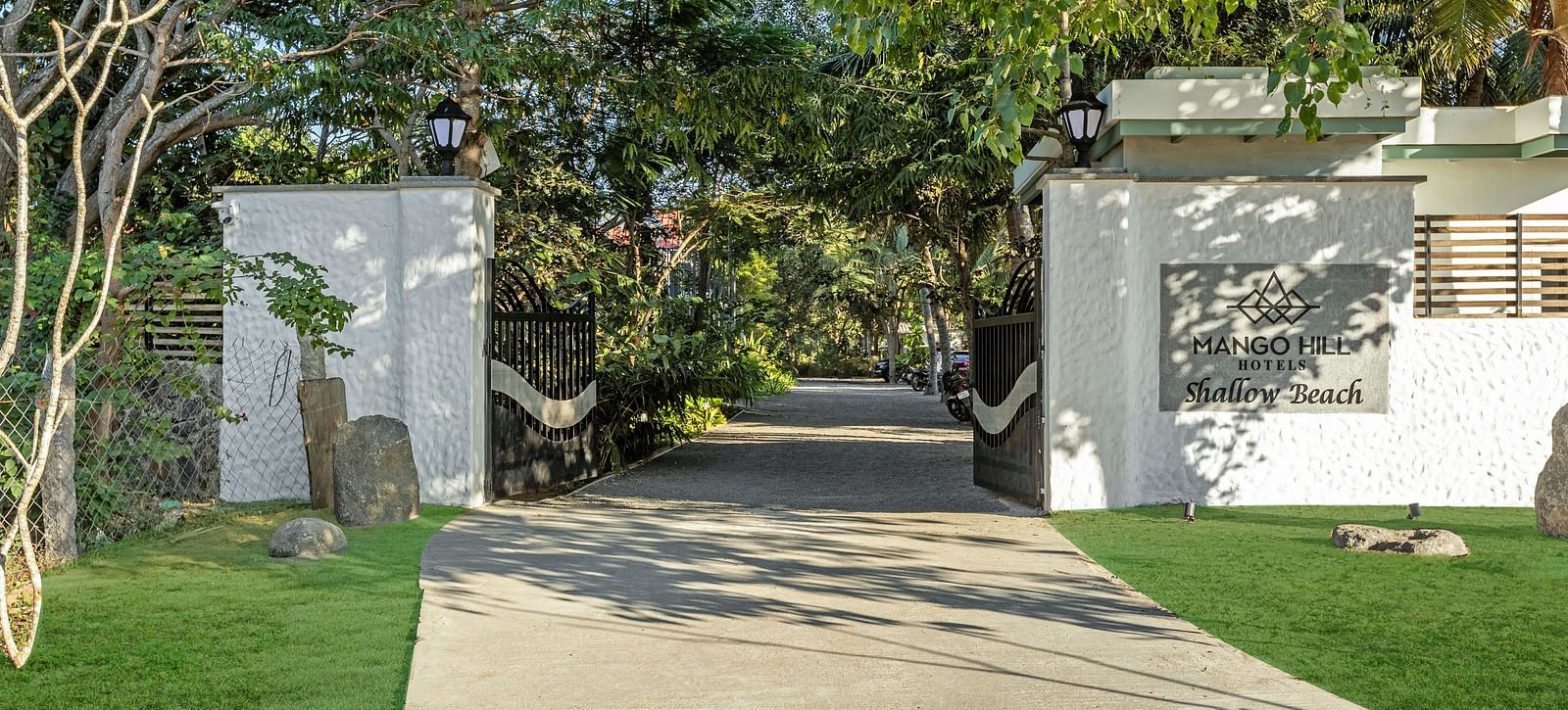 Resort entrance gate with a pathway leading through lush greenery to the Pondicherry wedding resorts | Mango Hill Shallow Beach Resort ECR